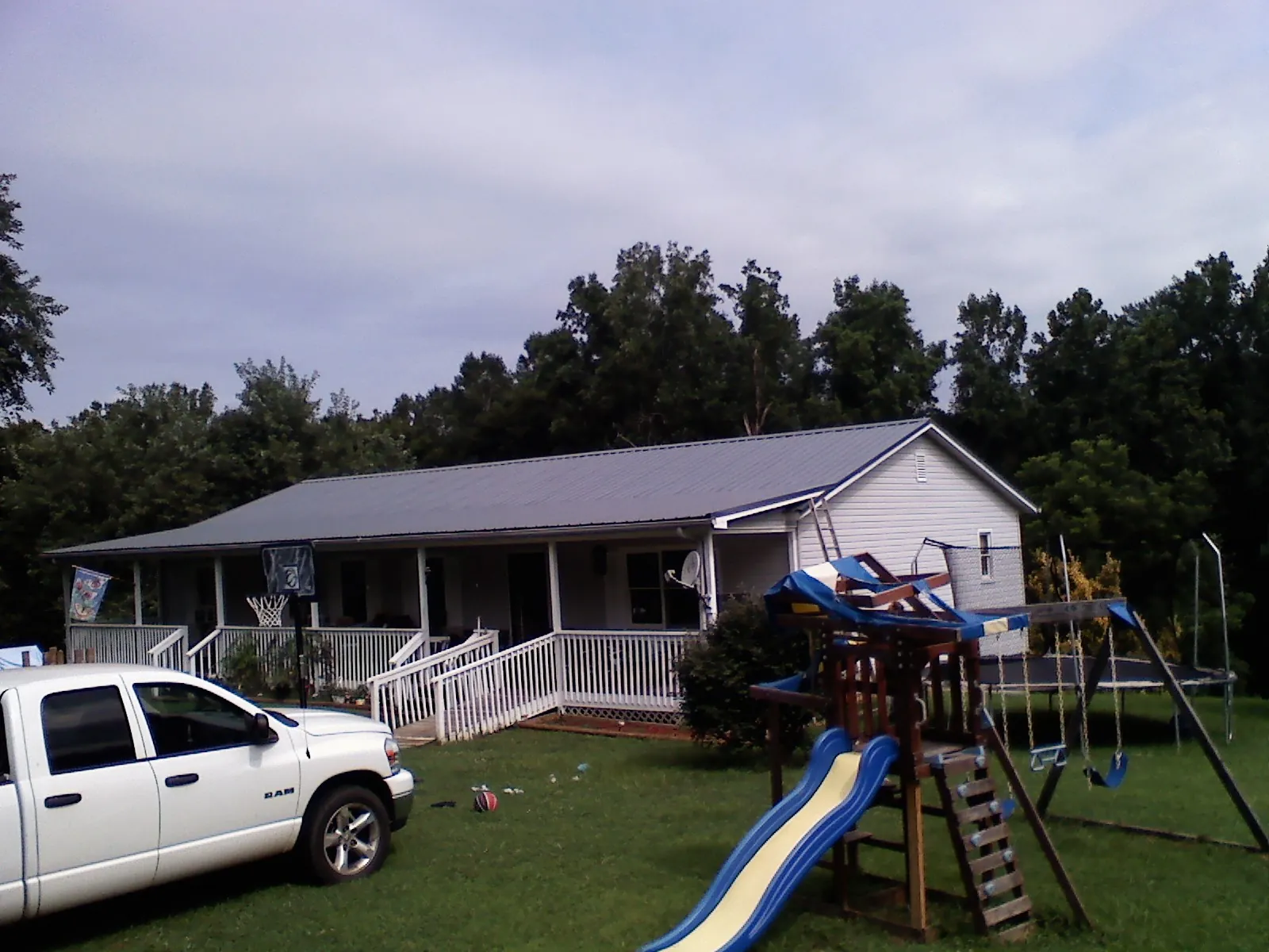 Dark metal roof on a country home with a full length front porch in Canaan