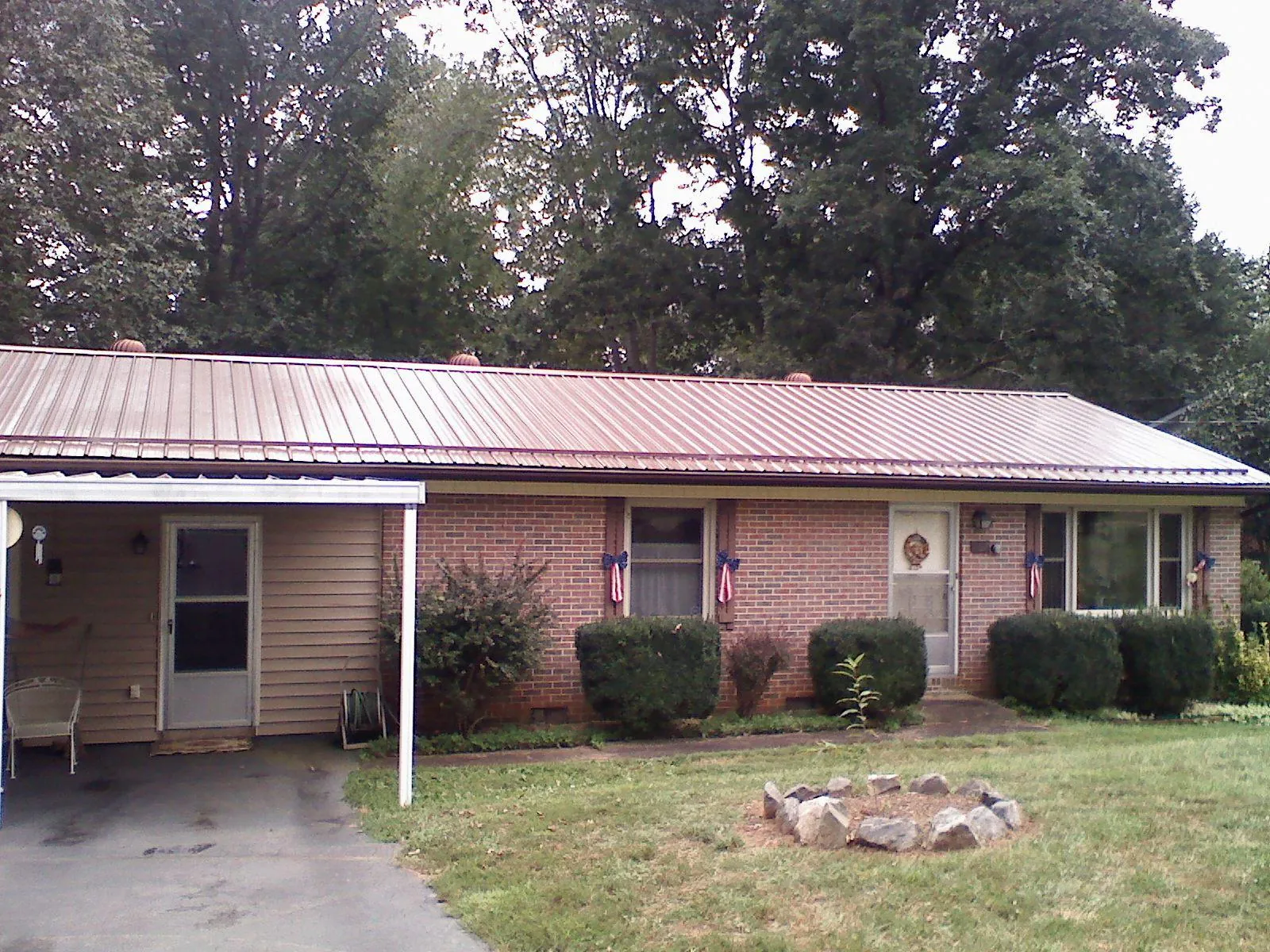 Bronze metal roof and carport on a brick ranch home — Roof Repair work by our crew in Canaan